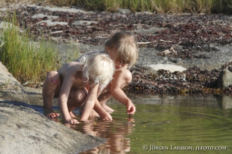 Barn leker vid vatten. Tjusts skärgård Småland