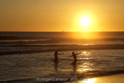 Maspalomas. Sunset at the beach with two bathining Girls