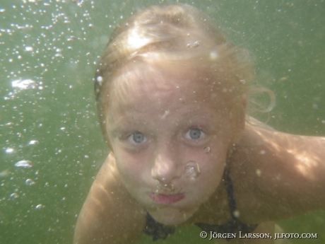 Flicka dyker under vattnet