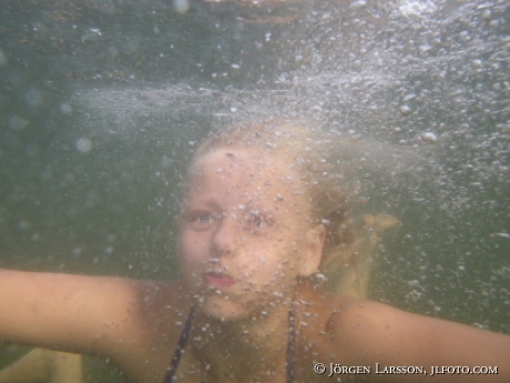 Flicka dyker under vattnet