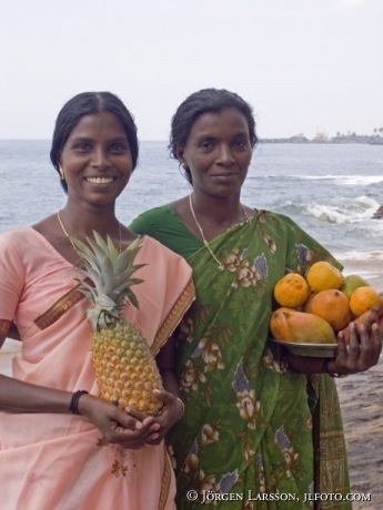 Kvinnor med frukt Coconut beach Kerala Indien